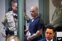 FILE - Clark County Public Administrator Robert Telles is escorted into court, Sept. 8, 2022, in Las Vegas. Telles was arrested in the fatal stabbing of Las Vegas Review-Journal reporter Jeff German.