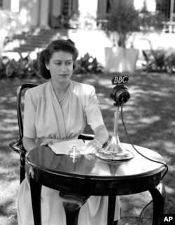 FILE - Britain's Princess Elizabeth, later Queen Elizabeth II, poses in front of a microphone to make a 21st birthday speech, April 21, 1947, which she made from Cape Town, South Africa.