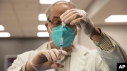 Seorang petugas kesehatan Gerard Diebner tengah menyiapkan vaksin COVID-19 untuk para penghuni panti wreda di Harlem, New York, pada 15 Januari 2021. (Foto: AP/Yuki Iwamura)