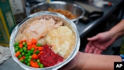 Volunteers prepare individual Thanksgiving meals for seniors in Hawthorne, N.J., on Nov. 3, 2020. With a fall surge of coronavirus infections gripping the US, many Americans are forgoing tradition and getting creative with celebrations.
