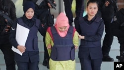 Indonesian Siti Aisyah, center, escorted by police, leaves Shah Alam High Court after a court hearing in Shah Alam, Malaysia on Tuesday, Dec. 18, 2018. 