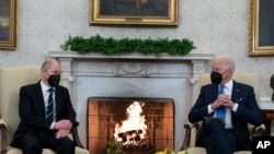 El presidente Joe Biden (der) conversa durante una reunión con el canciller alemán Olaf Scholz, en la Casa Blanca, en Washington, el 7 de febrero de 2022. 