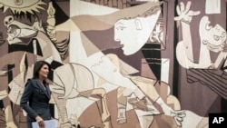 FILE - In this Jan. 2, 2018, photo, then-United States Ambassador to the United Nations Nikki Haley walks past a tapestry woven by Atelier J. de la Baume-Durrbach of Pablo Picasso's "Guernica."