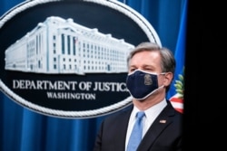 FILE - FBI Director Christopher Wray listens during a virtual news conference at the Department of Justice, Oct. 28, 2020.