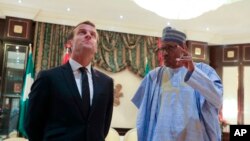 Le président français Emmanuel Macron, à gauche, écoutant son homologue nigérian Muhammadu Buhari à Abuja, le 3 juillet 2018.
