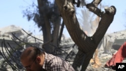 In this photo taken on a government-organized tour a local resident comfort reacts near ruins of destroyed building in the city of Surman, some 60 km west of Tripoli, Libya, on Monday, June 20, 2011.