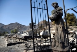 A religious statue stands amongst destroyed properties in the Seminole Springs Mobile Home Park, Nov. 11, 2018, after wildfires tore through the neighborhood in Agoura Hills, California.