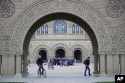 FILE - Students walk on campus at Stanford University in Stanford, Calif., Jan. 13, 2016.