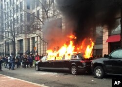 Protesters set a parked limousine on fire in downtown Washington during the inauguration of President Donald Trump, Jan. 20, 2017.