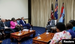 U.S. Secretary of State John Kerry (C) talks to Kenya's President Uhuru Kenyatta during their bilateral talks as other officials from Kenya and the U.S. listen., at the State House in Kenya's capital Nairobi, Aug. 22, 2016.