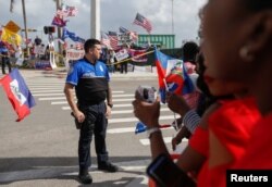 Police stand guard as protesters and supporters of U.S. President Donald Trump gather near Mar-a-Lago, Florida, Jan. 15, 2018.