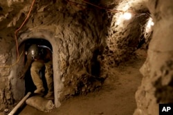 A member of the Border Patrol's Border Tunnel Entry Team enters a tunnel spanning the border between San Diego and Tijuana, Mexico, in San Diego, March 6, 2017.