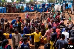 FILE - Displaced Gedeo people wait in line with their containers looking for water at Kercha site, West Guji in Ethiopia, Aug. 1, 2018.