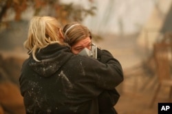 Krystin Harvey, left, comforts her daughter Araya Cipollini at the remains of their home burned in the Camp Fire, Nov. 10, 2018, in Paradise, Calif.