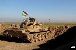 FILE - In this photo released by the Kurdistan Region Security Council, Kurdish peshmerga forces prepare on the front line for battle against Islamic State group positions, in northern Iraq, Jan. 20, 2015.