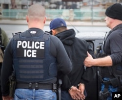 FILE - U.S. Immigration and Customs Enforcement (ICE) agents arrest foreign nationals, Feb. 7, 2017, in Los Angeles. In New York on Tuesday a lawyer threatened to call ICE because he heard cafe workers speaking Spanish.