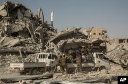 Members of the U.S.-backed Syrian Democratic Forces (SDF) ride near near the main traffic circle in Raqqa, Syria, Oct. 20, 2017. The day before, the SDF declared from the stadium during a ceremony the "total liberation" of Raqqa, the capital of the Islamic State for more than three years.
