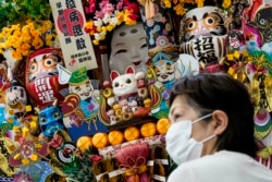 Seorang pembeli menunggu di toko suvenir di Olympic Pres Center Olimpiade Musim Panas 2020 di Tokyo, Jepang, Kamis, 22 Juli 2021. (Foto AP/John Minchillo)
