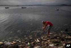A man washes himself in the polluted waters of Guanabara Bay in Rio de Janeiro, Brazil, July 30, 2016.