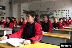 FILE PHOTO: Residents at the Kashgar city vocational educational training centre attend a Chinese lesson during a government organised visit in Kashgar, Xinjiang Uighur Autonomous Region, China, January 4, 2019. REUTERS/Ben Blanchard/File Photo