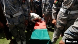 A relative kisses the coffin of an Afghan soldier, who was killed last night during a gun fight between Afghan border forces and Pakistani forces in Torkham, during his funeral in Nangarhar province, Afghanistan, June 14, 2016.