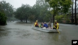 A FEMA rescue team evacuates people from a neighborhood in west Houston inundated by floodwaters from Tropical Storm Harvey on Monday, Aug. 28, 2017, in Houston, Texas.