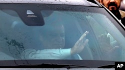 FILE - Pakistan's ousted Prime Minister Nawaz Sharif waves to supporters from his car while he leaves after appearing in an accountability court in Islamabad, Pakistan, Wednesday, Nov. 15, 2017.