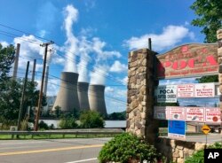 In this Aug. 23, 2018 photo, American Electric Power’s John Amos coal-fired plant in Winfield, West Virginia, is seen from the town of Poca across the Kanawha River.