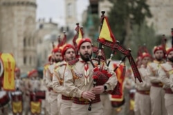 Palestinian scout band members parade through Manger Square at the Church of the Nativity, traditionally believed to be the birthplace of Jesus Christ, during Christmas celebrations, in the West Bank city of Bethlehem, Friday, Dec. 24, 2021.