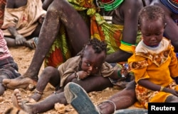 FILE - Turkana women and their children wait to receive relief food supplies near the Kakuma Refugee Camp, Turkana District, northwest of Kenya&#39;s capital Nairobi, August 8, 2011.