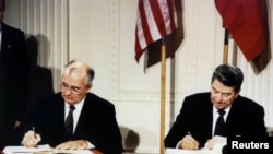 FILE - U.S. President Ronald Reagan (R) and Soviet President Mikhail Gorbachev sign the Intermediate-Range Nuclear Forces (INF) treaty at the White House in Washington, Dec. 8, 1987.