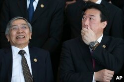 Haruhiko Kuroda, governor of the Bank of Japan, left, and Japan's Vice Finance Minister Minoru Kihara talk before posing for a group picture at the G-20 finance ministers and central bankers summit in Buenos Aires, Argentina, March 19, 2018.