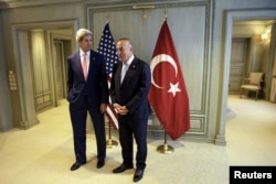 U.S. Secretary of State John Kerry, left, and Turkey's Foreign Minister Mevlut Cavusoglu wait for a meeting in Kuala Lumpur, August 5, 2015.