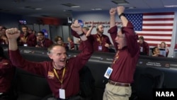 FILE - Mars InSight team react after receiving confirmation that the Mars InSight lander successfully touched down on the surface of Mars, Monday, Nov. 26, 2018 inside the Mission Support Area at NASA's Jet Propulsion Laboratory in Pasadena, California.