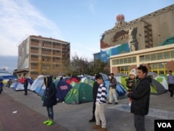 Thousands of refugees are living in tents and converted warehouses at Piraeus port, Athens. (Henry Ridgwell/VOA)