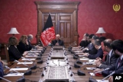 FILE - In this photo released by the Afghan Presidential Palace, Afghan President Ashraf Ghani, center, speaks to U.S. peace envoy Zalmay Khalilzad, third left, at the presidential palace in Kabul, Afghanistan, Jan. 28, 2019.