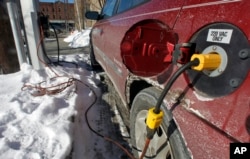 FILE - An electric car is charged in Montpelier, Vt., Jan. 18, 2013. With gas prices low, consumers are buying more trucks and SUVs and fewer fuel-efficient vehicles. That makes it harder to reach fleetwide gas mileage targets.