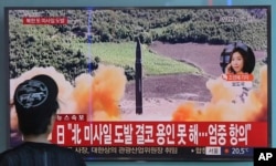 FILE - A woman watches a TV screen showing a file footage of North Korea's missile launch, at the Seoul Railway Station in Seoul, South Korea, Sept. 15, 2017.