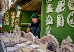 Vender Nils Knauerbstnads stands in his booth at the Christmas market in central Frankfurt, Germany, Nov. 23, 2021.