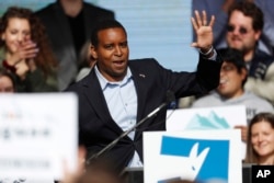 FILE - Then-candidate Joe Neguse greets voters on the campus of the University of Colorado in Boulder, Colo., Oct. 24, 2018.