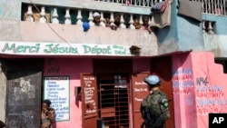FILE - Children watch from a balcony as a U.N. peacekeeper from Brazil patrols in the Cite Soleil slum, in Port-au-Prince, Haiti, Feb. 22, 2017.
