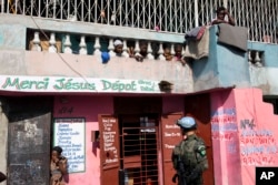 FILE - Children watch from a balcony as a U.N. peacekeeper from Brazil patrols in the Cite Soleil slum, in Port-au-Prince, Haiti, Feb. 22, 2017.
