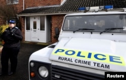 FILE - A police officer stands guard outside of the home of former Russian military intelligence officer Sergei Skripal, in Salisbury, Britain, March 6, 2018.