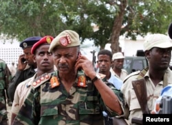 FILE - Somali military commander Abdulkadir Ali Dini speaks on a mobile phone at the scene of a suicide blast attack at Villa Baidoa in Mogadishu, Nov. 30, 2011.