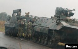 Soldiers stand beside military vehicles just outside Harare, Zimbabwe, Nov. 14,2017.
