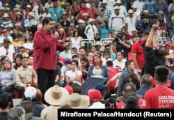 FILE - Venezuela's President Nicolas Maduro, left, speaks during a gathering in support of him and his proposal for the National Constituent Assembly in Caracas, Venezuela, June 27, 2017.