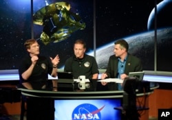 New Horizons Scientist Hal Weaver, left, talks with Mark Holdridge, center, and Mike Buckley as they await information from from the New Horizons spacecraft as it passes Pluto, July 14, 2015, in Laurel, Md.