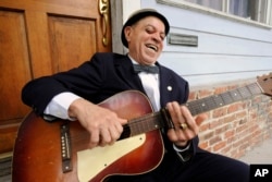 Musician "Deacon" John Moore, 74, holds his guitar in New Orleans, Louisiana, April 12, 2016.