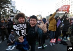 Protesters celebrate after hearing the news of President Park Geun-hye's impeachment in front of the National Assembly in Seoul, South Korea, Dec. 9, 2016.