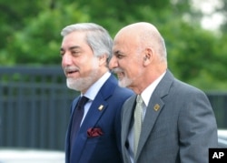 FILE - Afghanistan's President Ashraf Ghani, right, and Chief Executive Abdullah Abdullah arrive for sessions of the second day of the NATO Summit, in Warsaw, Poland, Saturday, July 9, 2016.
